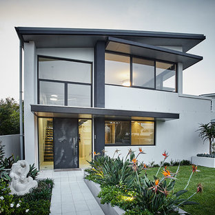 シドニーのコンテンポラリースタイルのおしゃれな二階建ての家 (ガラスサイディング、グレーの外壁、片流れ屋根) の写真