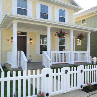 シーダーラピッズのトラディショナルスタイルのおしゃれな家の外観 (木材サイディング、黄色い外壁) の写真