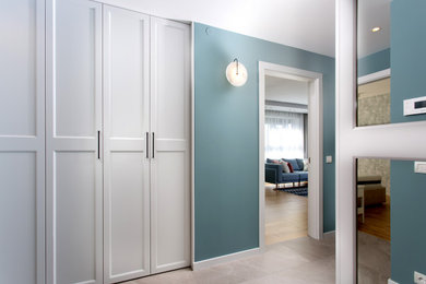 他の地域にある小さなコンテンポラリースタイルのおしゃれな玄関ホール (青い壁、大理石の床、グレーの床) の写真