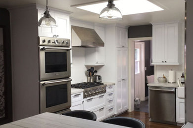 Mid-sized elegant single-wall dark wood floor and brown floor eat-in kitchen photo in San Diego with a drop-in sink, recessed-panel cabinets, white cabinets, quartz countertops, white backsplash, subway tile backsplash, stainless steel appliances and no island