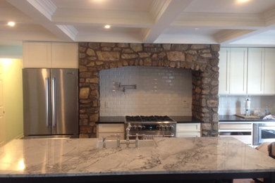 Example of a transitional medium tone wood floor kitchen design in Toronto with a farmhouse sink, shaker cabinets, white cabinets, marble countertops, white backsplash, subway tile backsplash, stainless steel appliances and an island