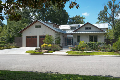 Inspiration for a large cottage beige two-story wood exterior home remodel in Houston with a metal roof