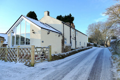 Ejemplo de fachada de casa blanca y gris clásica grande de dos plantas con revestimiento de estuco, tejado a dos aguas y tejado de teja de barro