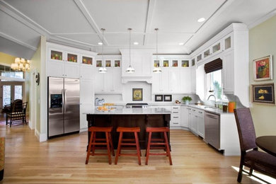 Inspiration for a mid-sized timeless l-shaped light wood floor and beige floor open concept kitchen remodel in Salt Lake City with an undermount sink, recessed-panel cabinets, white cabinets, marble countertops, white backsplash, wood backsplash, stainless steel appliances and an island
