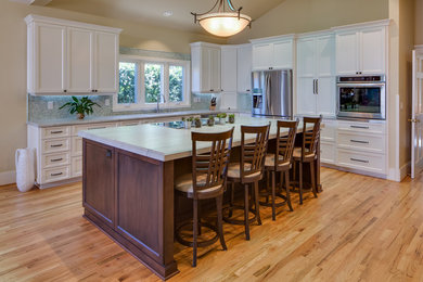 Design ideas for a large transitional open plan kitchen in San Diego with an undermount sink, shaker cabinets, white cabinets, quartzite benchtops, blue splashback, mosaic tile splashback, stainless steel appliances, light hardwood floors, with island and brown floor.