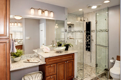 Bathroom - mid-sized transitional master gray tile and porcelain tile porcelain tile, beige floor and double-sink bathroom idea in DC Metro with medium tone wood cabinets, a one-piece toilet, gray walls, a vessel sink, granite countertops, a hinged shower door, beaded inset cabinets, gray countertops, a niche and a built-in vanity