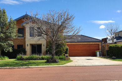 Photo of a large traditional attached three-car garage in Perth.