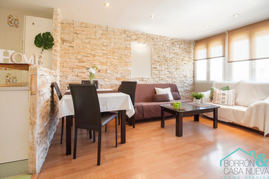 Diseño de salón abierto moderno pequeño con paredes beige, suelo laminado, televisor independiente y suelo marrón