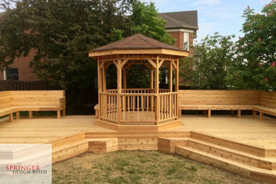 Deck - large traditional backyard deck idea in Toronto with a pergola