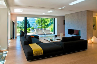 Idées déco pour un grand salon contemporain ouvert avec une salle de réception, un mur blanc, parquet clair, un manteau de cheminée en plâtre, un sol beige, une cheminée double-face et aucun téléviseur.