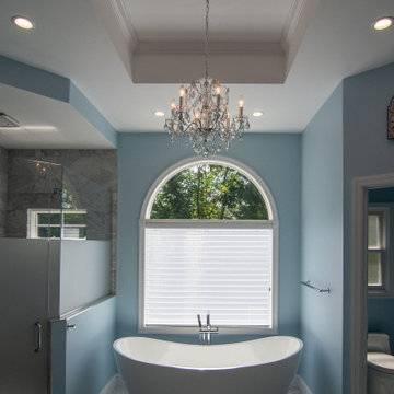 Traditional master bath utilizing frosted and clear glass to allow for needed pr