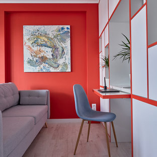 Immagine di uno studio design con pareti rosse, parquet chiaro, scrivania incassata e pavimento beige
