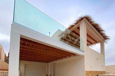 Ejemplo de terraza contemporánea de tamaño medio en azotea con pérgola y barandilla de vidrio