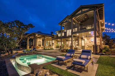 Large mountain style backyard concrete paver patio photo in Other with a fireplace and a roof extension