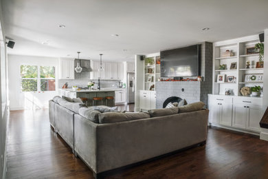Mid-sized 1960s open concept dark wood floor and brown floor living room photo in Dallas with white walls, a standard fireplace, a brick fireplace and a wall-mounted tv