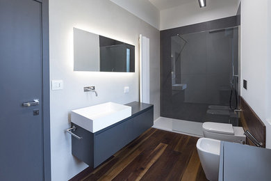 Idee per un bagno di servizio minimalista con ante in legno bruno, WC a due pezzi, piastrelle in gres porcellanato, parquet scuro, lavabo rettangolare e pavimento marrone