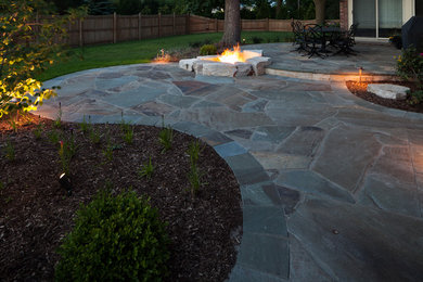 Photo of a mid-sized traditional backyard patio in Milwaukee with a fire feature, natural stone pavers and no cover.