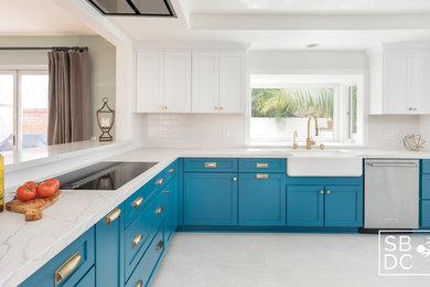 Mid-sized beach style u-shaped porcelain tile and gray floor enclosed kitchen photo in Los Angeles with a farmhouse sink, shaker cabinets, turquoise cabinets, quartz countertops, white backsplash, subway tile backsplash, stainless steel appliances, no island and white countertops