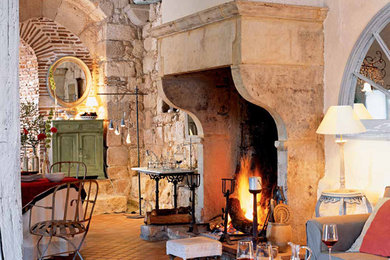 Example of a large tuscan open concept terra-cotta tile living room design in New York with beige walls, a standard fireplace, a stone fireplace and no tv
