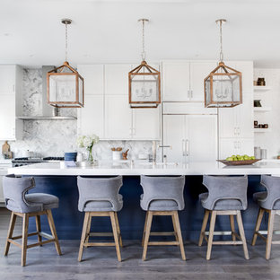 Выдающиеся фото от архитекторов и дизайнеров интерьера: большая угловая кухня-гостиная в морском стиле с врезной раковиной, фасадами в стиле шейкер, столешницей из кварцевого композита, белым фартуком, фартуком из мрамора, техникой из нержавеющей стали, паркетным полом среднего тона, островом, белой столешницей, коричневым полом и белыми фасадами
