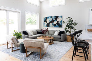 Living room - large coastal open concept light wood floor and brown floor living room idea in Los Angeles with gray walls, a standard fireplace, a tile fireplace and a media wall