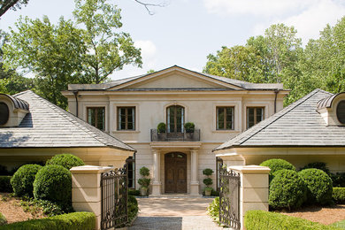 This is an example of a large traditional two-storey stucco beige exterior in Atlanta with a hip roof.