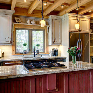 This is an example of a small country galley kitchen pantry in Toronto with an undermount sink, recessed-panel cabinets, distressed cabinets, granite benchtops, beige splashback, glass tile splashback, stainless steel appliances, dark hardwood floors and with island.