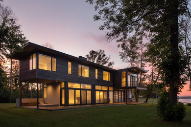 Inspiration for a large contemporary two-story exterior home remodel in Milwaukee with a black roof