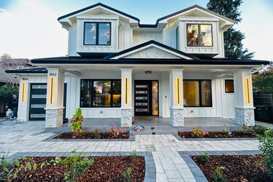 Example of a mid-sized cottage white two-story mixed siding and board and batten exterior home design in San Francisco with a metal roof and a black roof