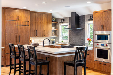 Eat-in kitchen - contemporary l-shaped light wood floor eat-in kitchen idea in San Francisco with an undermount sink, flat-panel cabinets, medium tone wood cabinets, quartz countertops, beige backsplash, subway tile backsplash, black appliances, an island and white countertops