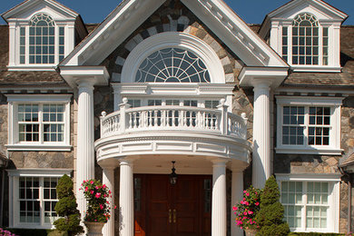 Inspiration for a huge timeless white three-story stone gable roof remodel in New York