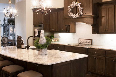 Inspiration for a large farmhouse galley dark wood floor and brown floor open concept kitchen remodel in Little Rock with a farmhouse sink, shaker cabinets, dark wood cabinets, granite countertops, white backsplash, brick backsplash, an island and stainless steel appliances