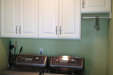 シャーロットにある低価格の小さなトラディショナルスタイルのおしゃれな洗濯室 (L型、スロップシンク、レイズドパネル扉のキャビネット、白いキャビネット、緑の壁、左右配置の洗濯機・乾燥機) の写真