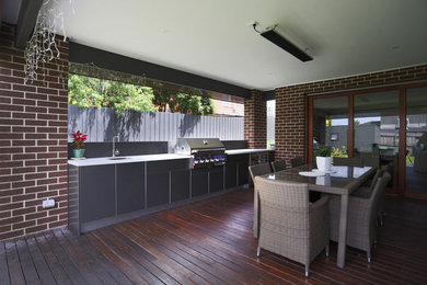 Photo of a large modern backyard deck in Melbourne with an outdoor kitchen.