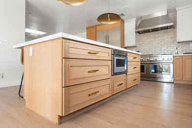 Inspiration for a mid-sized contemporary l-shaped light wood floor and brown floor eat-in kitchen remodel in Los Angeles with an undermount sink, shaker cabinets, medium tone wood cabinets, quartz countertops, beige backsplash, porcelain backsplash, stainless steel appliances, an island and white countertops