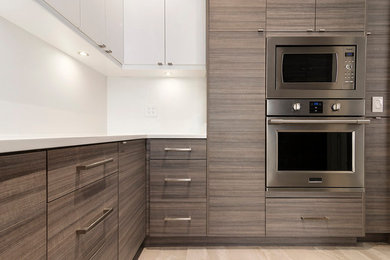 Open concept kitchen - large contemporary u-shaped porcelain tile and gray floor open concept kitchen idea in Vancouver with an undermount sink, flat-panel cabinets, gray cabinets, quartzite countertops, white backsplash, stainless steel appliances, an island and white countertops