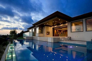 Inspiration for a contemporary backyard rectangular infinity pool remodel in Orange County