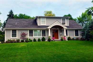 Modelo de fachada de casa gris y gris clásica grande de dos plantas con revestimiento de vinilo, tejado a dos aguas, tejado de teja de madera y tablilla