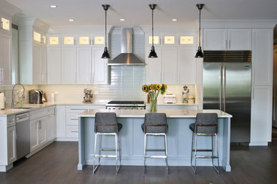 Example of a large minimalist l-shaped medium tone wood floor and gray floor eat-in kitchen design in Chicago with raised-panel cabinets, white cabinets, quartz countertops, white backsplash, subway tile backsplash, stainless steel appliances, an island and white countertops