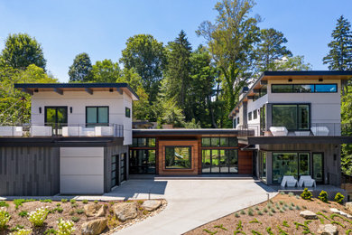 Large trendy multicolored two-story mixed siding house exterior photo in Other with a shed roof and a mixed material roof