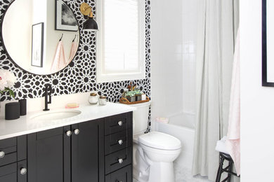 Small traditional bathroom in Toronto with an alcove tub, a shower/bathtub combo, white tile, an undermount sink, shaker cabinets, black cabinets, multi-coloured walls and mosaic tile floors.