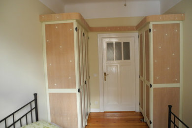 Kleines Klassisches Schlafzimmer mit beiger Wandfarbe und hellem Holzboden in Berlin