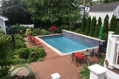 Inspiration for a mid-sized contemporary backyard rectangular pool remodel in New York with decking