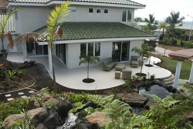 Design ideas for a large tropical two-storey grey house exterior in Hawaii with stone veneer, a hip roof and a shingle roof.