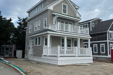 Small coastal beige three-story wood exterior home idea in Boston with a shingle roof and a black roof