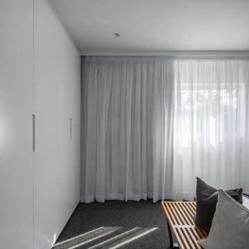 Bedroom with built in wardrobe and linen curtains