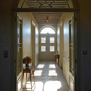 Exempel på en mycket stor klassisk hall, med beige väggar och kalkstensgolv