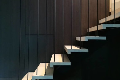 Foto de escalera recta actual de tamaño medio sin contrahuella con escalones de madera y barandilla de metal