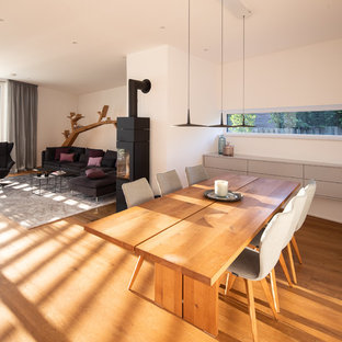 ブレーメンの広いコンテンポラリースタイルのLDKの画像 (白い壁、無垢フローリング、薪ストーブ、金属の暖炉まわり、茶色い床)