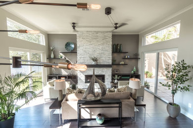Inspiration for a large transitional open concept living room in Miami with grey walls, porcelain floors, a tile fireplace surround and brown floor.